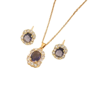 Elegant gold necklace and earrings set featuring oval dark purple zircon gemstones