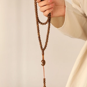 Detailed view of 99-bead wooden Tasbih with crescent moon pendant in natural wood style
