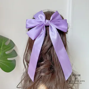 Detail einer seidigen lila Haarschleife mit langen Bändern an einer eleganten Frisur