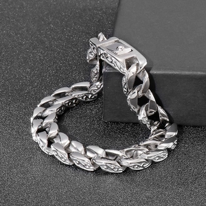 Detail of silver stainless steel Cuban link bracelet with intricate floral side engraving