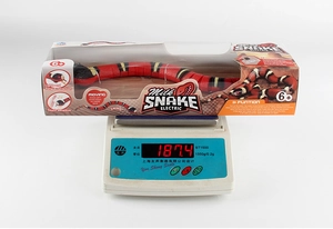 Detailed view of realistic electric milk snake toy on a scale weighing 187.4g with box