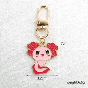 Détail macro d'un porte-clés axolotl en émail rose montrant les dimensions 7 cm x 3,2 cm