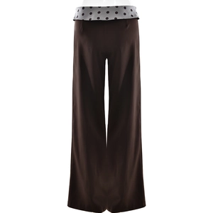 Detail of high-waist straight leg trousers featuring polka dot patchwork waistband