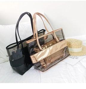 Chic transparent PVC tote bags with metallic trim set on beach-themed background