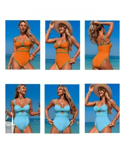 Detail view of textured one-piece swimsuits with contrast piping and cutout in blue and orange