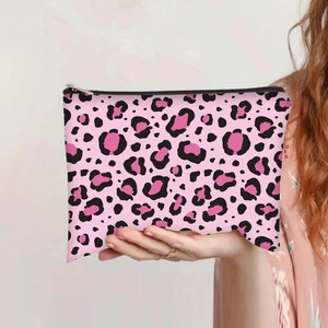 Close-up of pink leopard print canvas pouch with feminine silhouette patterns and zipper