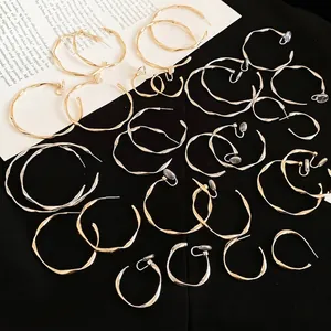 Minimalist twisted metal hoop earrings set in polished gold and silver finishes