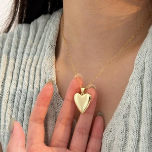 Elegant gold heart pendant necklace for women shown on a model with minimalist style