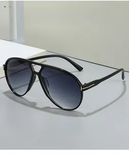 Detail of pilot sunglasses showing blue gradient lenses and golden T-hinge on black frame