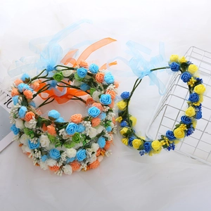Close-up of floral wreaths with blue and orange faux roses and elegant silk ribbons