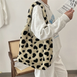 Detail of soft faux fur tote bag featuring a black heart pattern for winter fashion