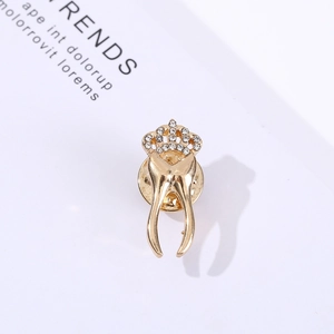Detail of creative gold-plated tooth crown brooch featuring sparkling rhinestone accents