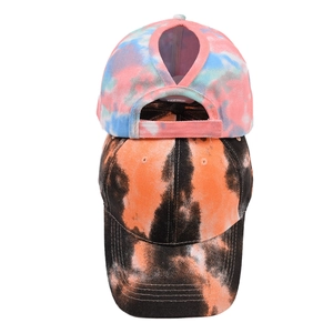Detail view of tie-dye ponytail baseball caps showing the rear opening and vibrant patterns