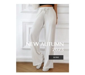 Detail of white wide-leg trousers featuring pleated fabric texture and drawstring waist