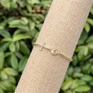 Dettaglio del bracciale con perline placcato oro 18k, croce di zirconi e ciondoli