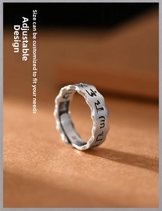 Macro shot of adjustable silver vintage ring with Sanskrit mantra and wavy edges
