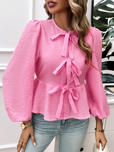 Pink plaid blouse detailing puff sleeves and three front bow ties with ruffled hem