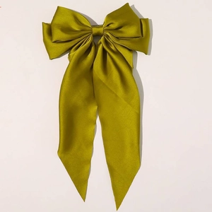 Detail of oversized olive green satin bow hair clip with smooth silk texture
