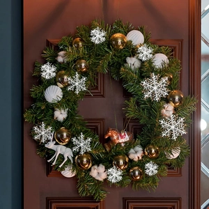 White snowflake ornaments with gold balls and cotton on a festive Christmas wreath