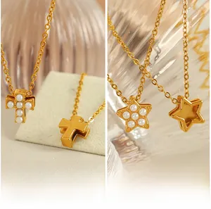 Détails de pendentifs dorés avec motifs étoile et croix et incrustations de perles blanches