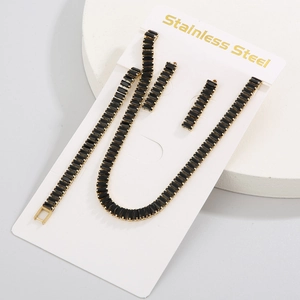 Detail of gold stainless steel jewelry set with black rectangular zircon on card
