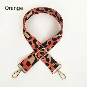 Detail of adjustable orange leopard print strap with gold metal hooks for handbags