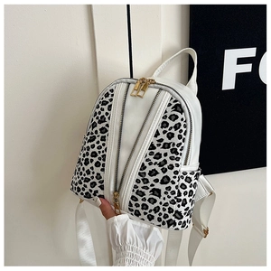Detail of white mini backpack with leopard print panels and dual zipper front pocket
