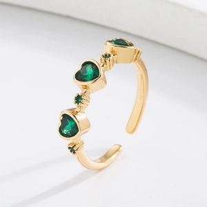 Macro detail of 18K gold plated ring featuring three heart-shaped green zircon gemstones