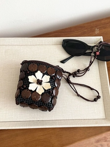 Detail of bohemian handmade coconut shell crossbody bag with white flower charm and beads