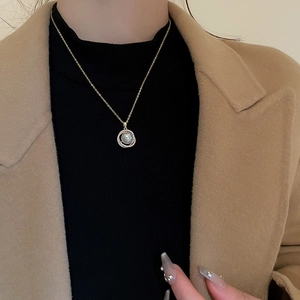 Détail d'un collier pendentif perle vintage avec halo de zircon porté par un mannequin