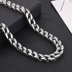 Macro view of silver Cuban link chain featuring vintage floral side engravings