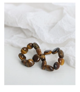 Macro shot of tiger eye stone beads on elastic bands arranged in an infinity shape