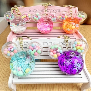 Detail of Mickey-shaped keychain with macaron beads and glitter flakes inside