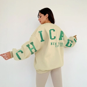 Détail de l'imprimé vert Chicago au dos d'un sweat-shirt beige à coupe surdimensionnée