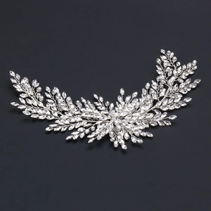 Macro detail of silver leaf crystal hairpiece with intricate rhinestones for bridal styling