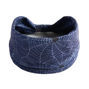 Detailed view of elastic navy blue yoga headband featuring white spider web patterns
