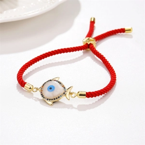 Detail of red braided evil eye bracelet with gold fish pendant and adjustable cord