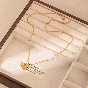 Dettaglio di un ciondolo a goccia in oro con micro diamanti su catena snake e scatola di legno