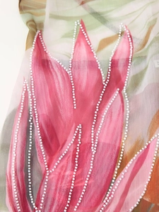 Détail macro de perles faites à la main sur tissu de robe en mousseline fleurie rose