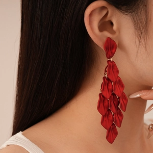 Red acrylic ruffled rose petal tassel earrings shown on a model for a vintage party look