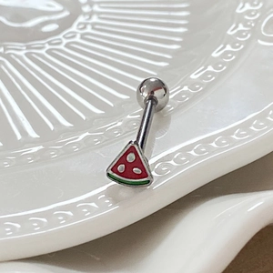 Macro view of watermelon enamel tongue ring with silver metal bar on white ceramic