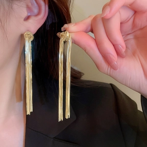 Elegant gold long tassel earrings with chain knot design on a model for a chic look
