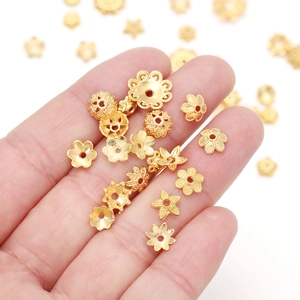 Primo piano di copriperle dorati e distanziatori cavi per la creazione di gioielli DIY