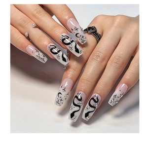Detail of long coffin nails with snake patterns and rhinestones on hands