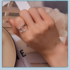 Close-up of s925 silver butterfly ring with hanging tassels on fashion magazine