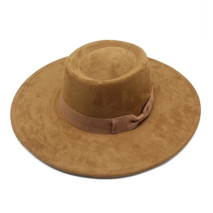 Détail du chapeau en suédine camel avec ruban décoratif et calotte plate élégante