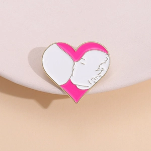 Macro detail of a heart-shaped enamel brooch featuring a mother and child silhouette