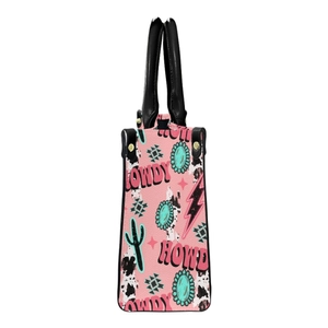 Pink HOWDY tote bag with western retro prints and black handles on a white background