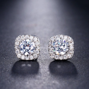 Macro shot of square silver stud earrings featuring round zircon with halo setting