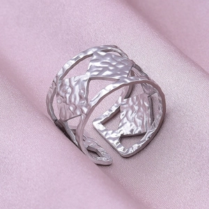 Detail of adjustable silver steel ring with geometric hollow design and hammered texture
